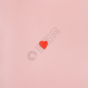 一个小心脏切出红纸的背景从浅粉色面纸的背景图片