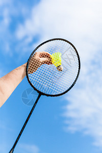 女用羽毛球花冠击打黄色的穿梭小孔雀背景来自蓝天白是云重点穿梭小孔雀图片