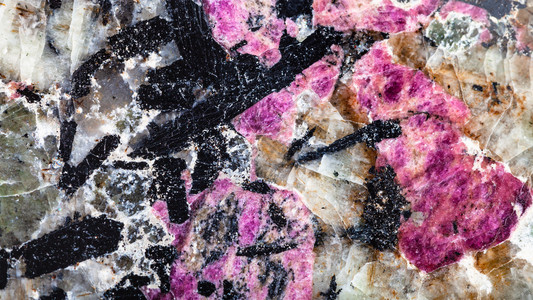 中英抛光天然锡石lujaurite岩石的全色背景这些岩石上含紫透析矿物和黑乙酰水晶接近尾声背景