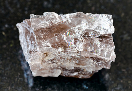 地质采集的天然矿物样本封存黑花岗岩背景的粗斯摩基夸尔茨岩石背景图片