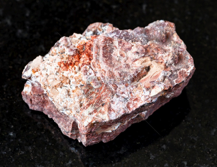 地质采集的天然矿物样本查封黑花岗岩背景上未分割的Rhyolite岩石图片