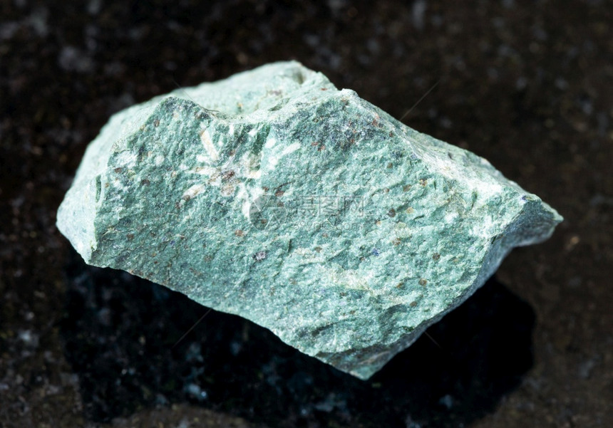 地质采集的天然矿物样本查封黑色花岗岩背景的生金瓜图片
