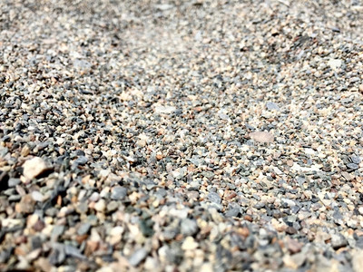 带有小石子的灰色沙滩背景图片