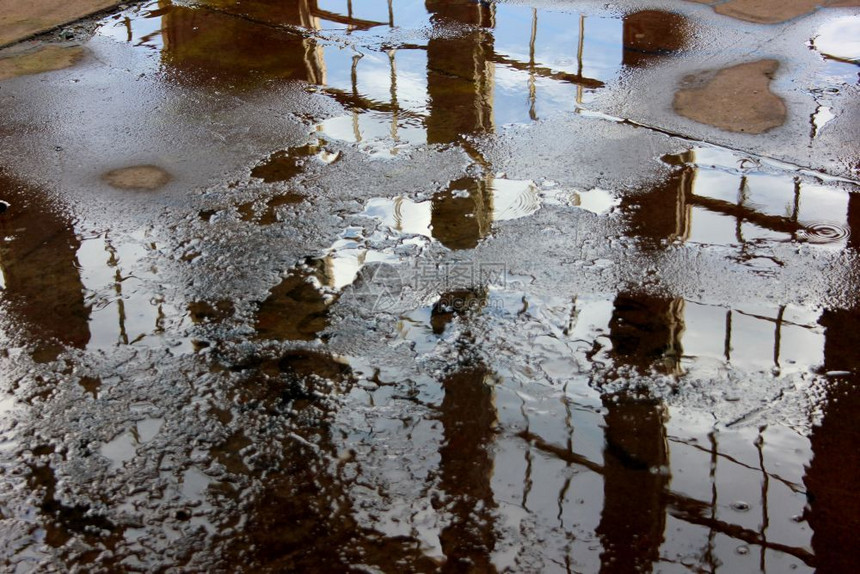 地面雨水倒映着窗户和天空的影子图片