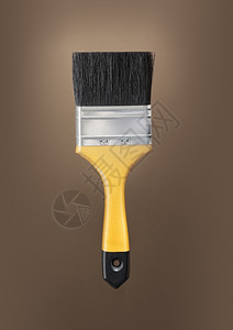 刷子棕色背景上的黄漆刷工具棕色的图片
