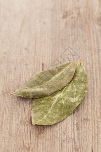 贵族味道香料Baylaurel树叶在木背景上被孤立背景图片