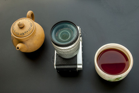 桌上放置的相机和茶水图片