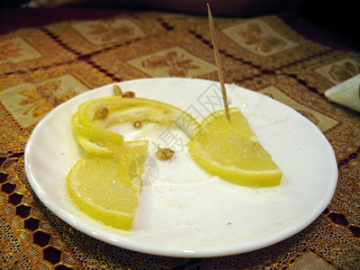 黄色的盘子上切柠檬骨头食物图片