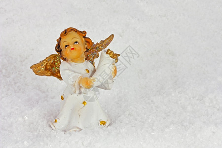 金色的圣诞小人在雪地上图片