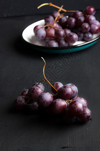 沙佛营养黑葡萄在色背景的盘子上一种图片