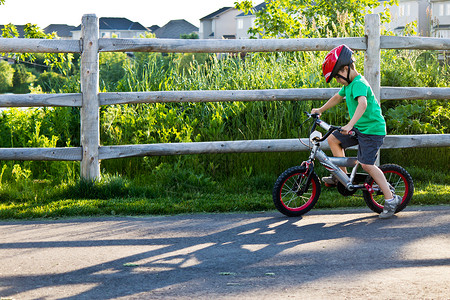 一学就会小男孩学骑自行车会孩子他的户外背景