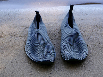 水鞋类沙子上的游泳拖鞋贴近了假期背景图片