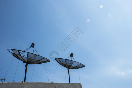 在屋顶上安装蓝色天空背景的卫星线盘通讯商业子图片