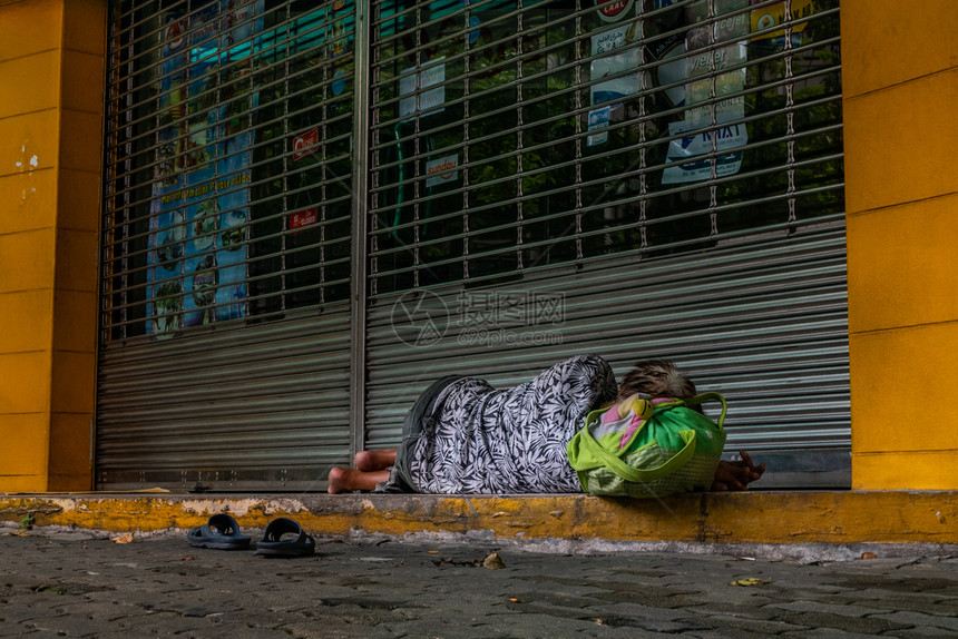 店铺2019年无家可归的赤脚妇女睡在封闭商店门前的单人行道上社会问题议赤足的图片