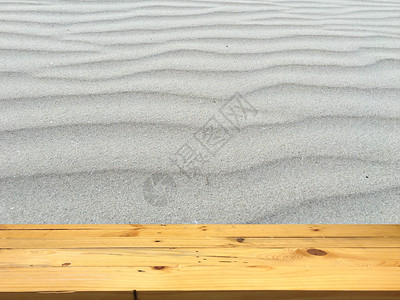 空白的木制桌子空间平台和产品显示蒙集的模糊海滩沙底背景图片
