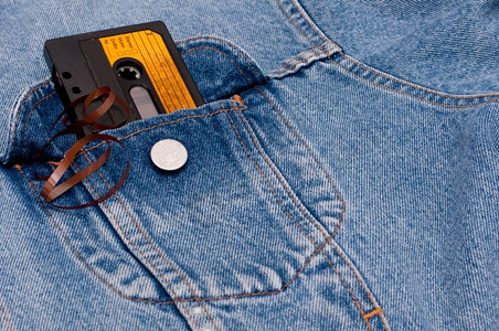 蓝色的Retro音乐蓝琴夹克口袋中的旧音频盒式磁带声老的图片
