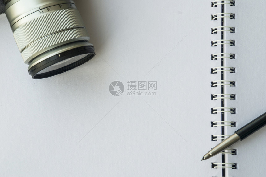 白色的一种金融照相机和笔放在白记本上准备工作图片