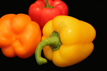 黑色背景红黄胡椒和素食主义者照片黄色的图片