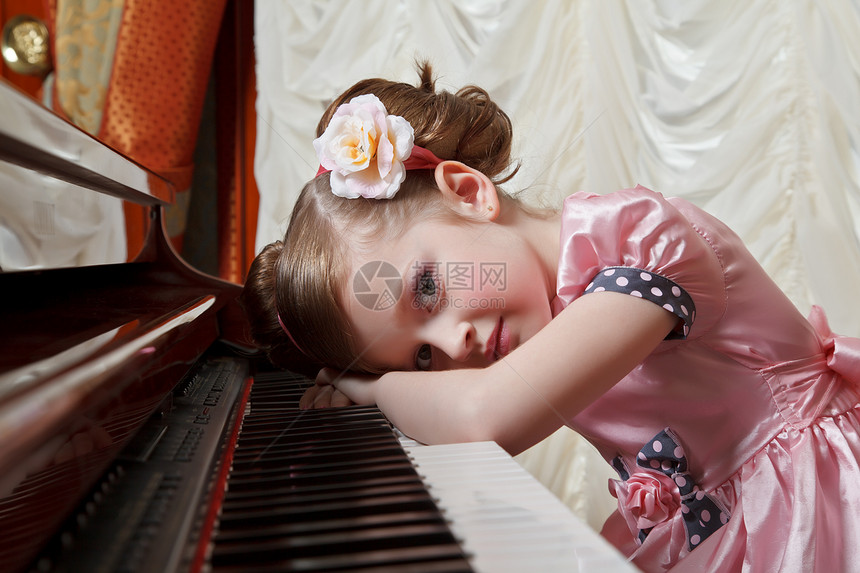 穿粉色衣服的小女孩弹钢琴图片