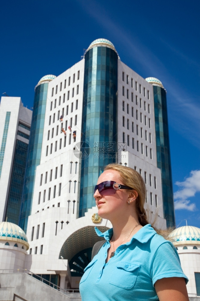 青年妇女和现代建筑哈萨克斯坦阿塔纳天空看阳光图片