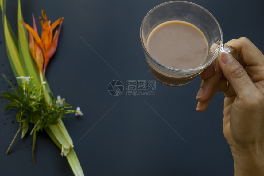 花一种杯咖啡在即将饮酒的女人手中此处叩头黑色的图片