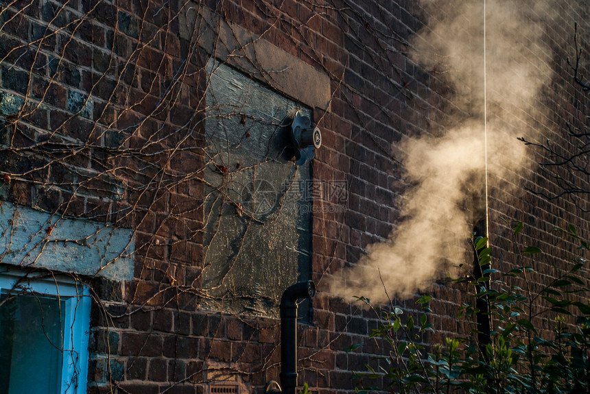 屋户外空气烟雾来自炉灶金属管清晨在房子后面图片