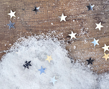 圣诞节木板背景上的亮星形状和雪冬天庆典背景图片