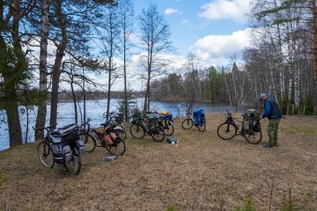 春天树木晴在俄罗斯阳光明媚的春季日自行车和湖岸骑的人图片