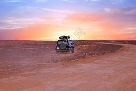 谢比黄昏荒野日落时驾车穿越摩洛哥撒哈拉沙漠图片