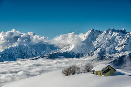 冬天雪中高山小屋和平全景图片