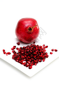 正方形小吃整亮红色石榴和白上隔离的方板可食用种子全亮红色石榴水果图片
