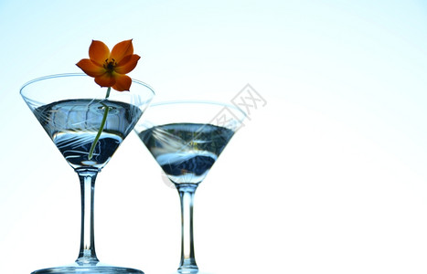 杜松子酒混合淡蓝色背景的马提尼鸡尾酒背景图片