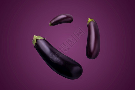 新鲜的目紫色背景中的三个茄子图片