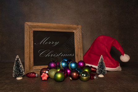 圣诞老人红色的假期黑板上印有圣诞快乐和白纸板上圣塔帽背景图片