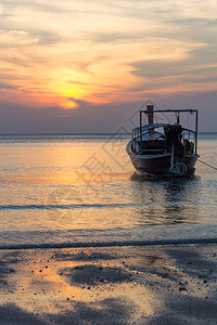 泰国Trang省PakNam海滩日落时的船董里悬崖设置水图片
