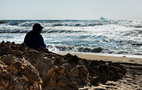 一个老人坐在海边图片