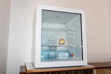 酒店电气苏打罐和水瓶放在一个小冰箱里在旅馆有玻璃门瓶子图片