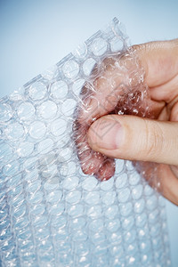 材料透明手指男人里握着一块泡包装图片