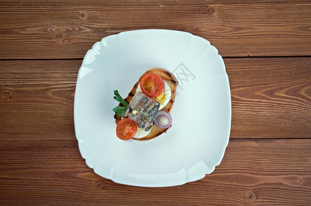 照片煮沸尼思吐司配鸡蛋鱼和樱桃番茄的三明治一顿饭图片