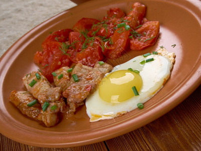 欧洲早餐鸡蛋培根和番茄吃勺子煮熟的图片
