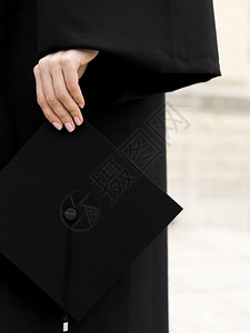 手拿毕业学术帽的学生图片