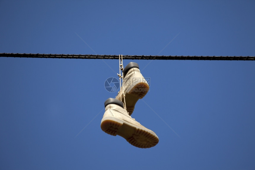 鞋挂在铁线上城市的绞刑靴子图片