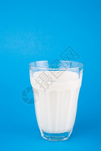 玻璃中的牛奶蓝底喝满的白色背景图片