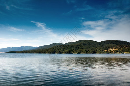 蓝天白云湖泊与山上的树木图片