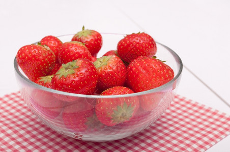 食物林顿桌玻璃碗里的新鲜草莓白色木制背景图片