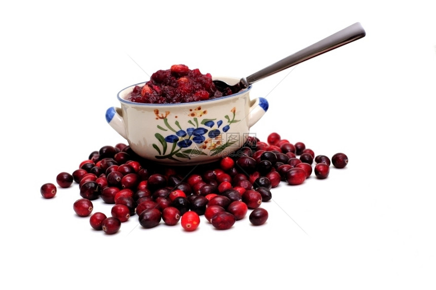一碗新鲜红莓酱的边景碗下有生红莓一碗新鲜酱在下面食用蔓越莓图片