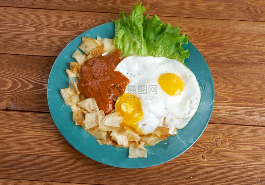 红色的传统Huevosconchilaquiles墨西哥传统早餐鸡蛋和玉米饼薯片的鸡蛋加红酱奇拉奎莱斯图片