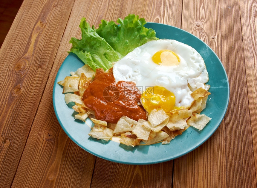 顶红色的Huevosconchilaquiles墨西哥传统早餐鸡蛋和玉米饼薯片的鸡蛋加红酱韦沃斯图片