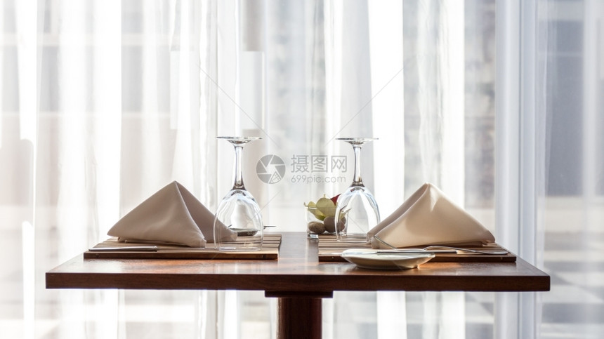 简单的一张精美的两张桌子配有餐巾布和红酒杯晚餐眼镜图片