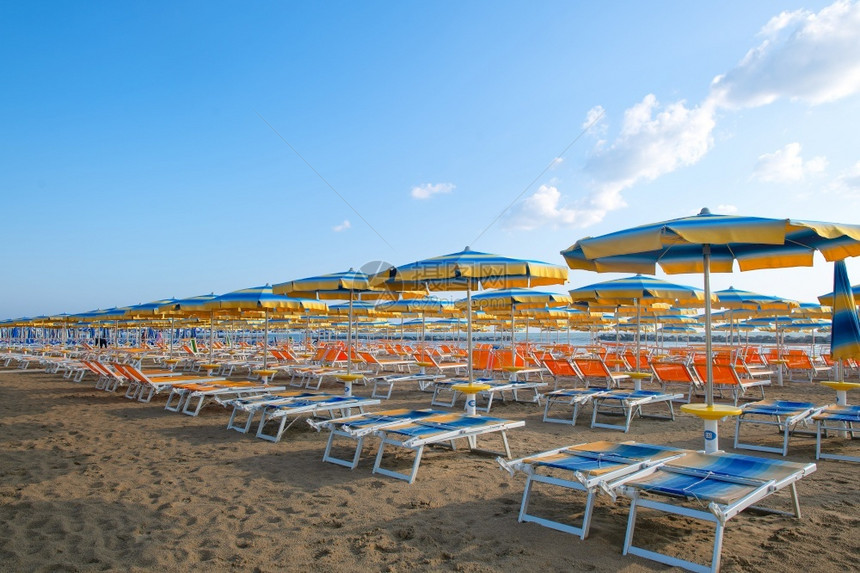 意大利亚得里罗马尼维埃拉海滩上的伞和遮晒者假期邻居棕褐色图片